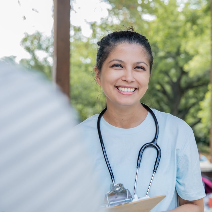 Friendly female nurse talks to patient during a community outreach health fair event